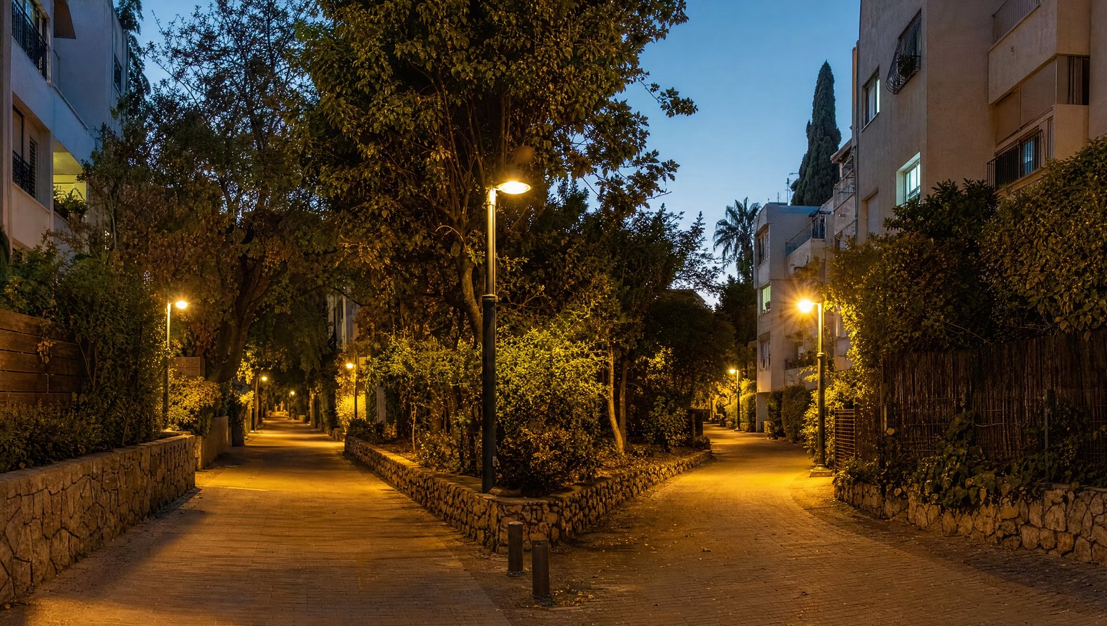 רחוב מגורים ברמת גן שמתפצל לשתי דרכים בשעת בין ערביים